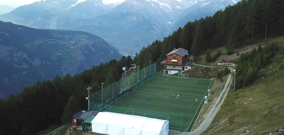 Football pitch surrounded by mountains.